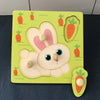 Montessori wooden puzzle featuring a cute bunny and carrot pieces, enhancing toddler fine motor skills and learning through play.