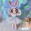 Fashion doll in bunny outfit with delicate design and lifelike features, posed against a colorful background.