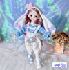 Fashion doll dressed in blue and white outfit with bunny ears, standing on a fluffy surface, featuring lifelike details.