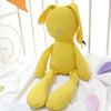 Yellow plush bunny doll sitting on a white bed, showcasing its ultra-soft fabric and adorable design for babies and toddlers.