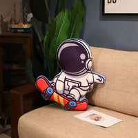 Plush astronaut skateboarding pillow on a sofa, perfect for space-themed decor and cuddly gifts for kids.