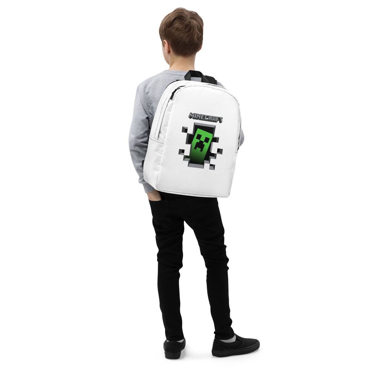 Boy wearing backpack with Minecraft Creeper design, featuring a minimalist style and spacious compartments.