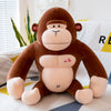 Plush orangutan toy with heart details sitting on a colorful bedspread, made from ultra-soft stretch velvet fabric.