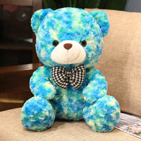 Blue and green teddy bear plush doll with bow tie on sofa, perfect Valentine’s Day or birthday gift for loved ones.