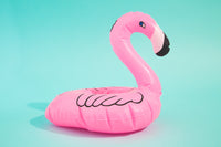 Pink inflatable flamingo pool float against a bright blue background.